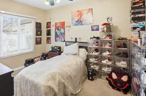 Bedroom with light colored carpet and a ceiling fan