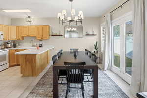 Dining area with suspended lighting and light tile patterned flooring