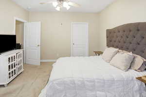 Bedroom with light colored carpet and ceiling fan