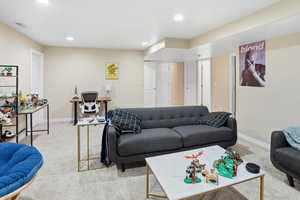 Living room with light colored carpet and recessed lighting