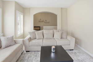 Living area with carpet floors and arched walkways
