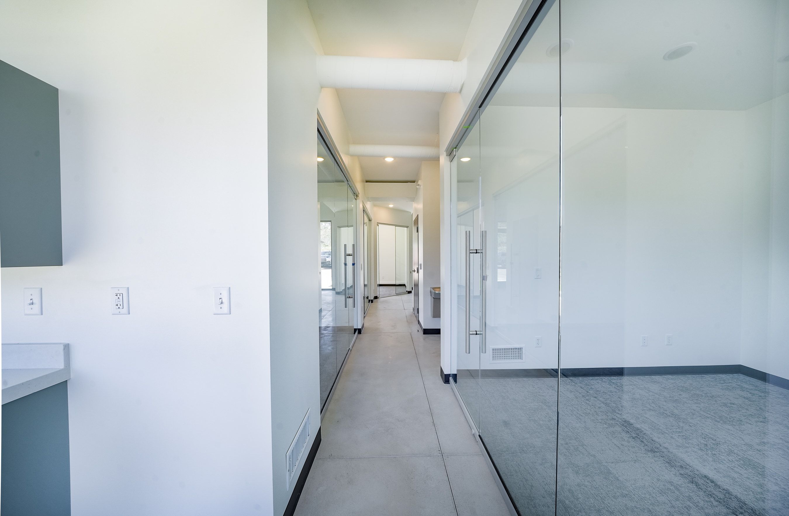 Hallway featuring concrete floors and recessed lighting