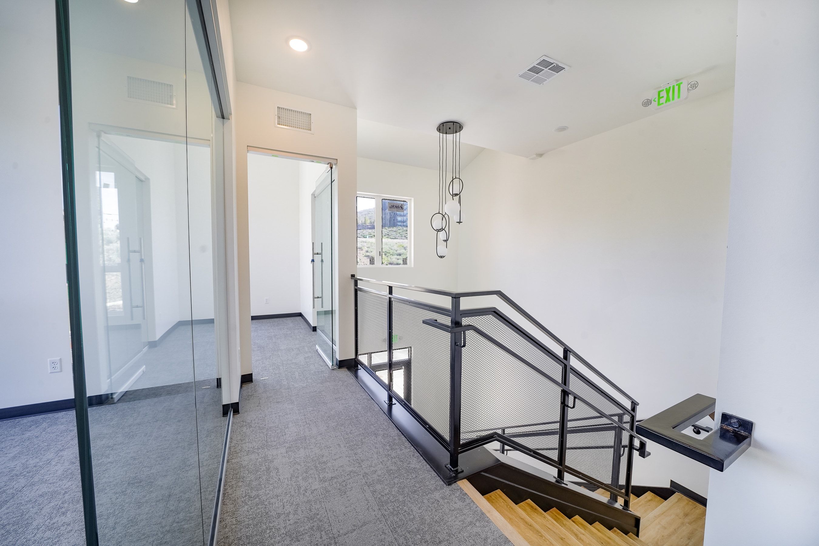 Hallway featuring an upstairs landing and light colored carpet