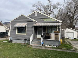 Bungalow with an outbuilding, a garage, and a porch