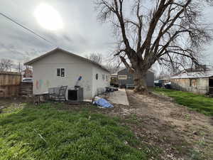 Back of garage with a patio and stucco siding