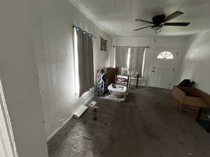 Living area with a ceiling fan and baseboards