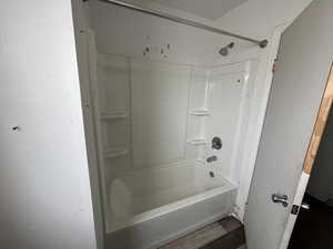 Bathroom featuring light wood-style flooring and shower / washtub combination