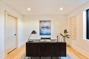 Office space featuring light wood-style flooring and recessed lighting