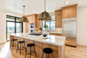 Kitchen with stainless steel appliances, a breakfast bar, and light wood finish cabinets