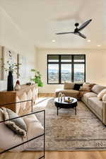 Living area with wood finished floors, a mountain view, and a ceiling fan