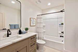 Full bathroom with vanity, shower / tub combo, and recessed lighting