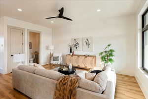 Living area with a ceiling fan, light wood finished floors, and recessed lighting