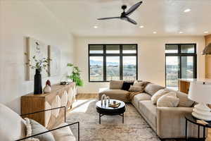 Living area with light wood finished floors, a ceiling fan, and recessed lighting