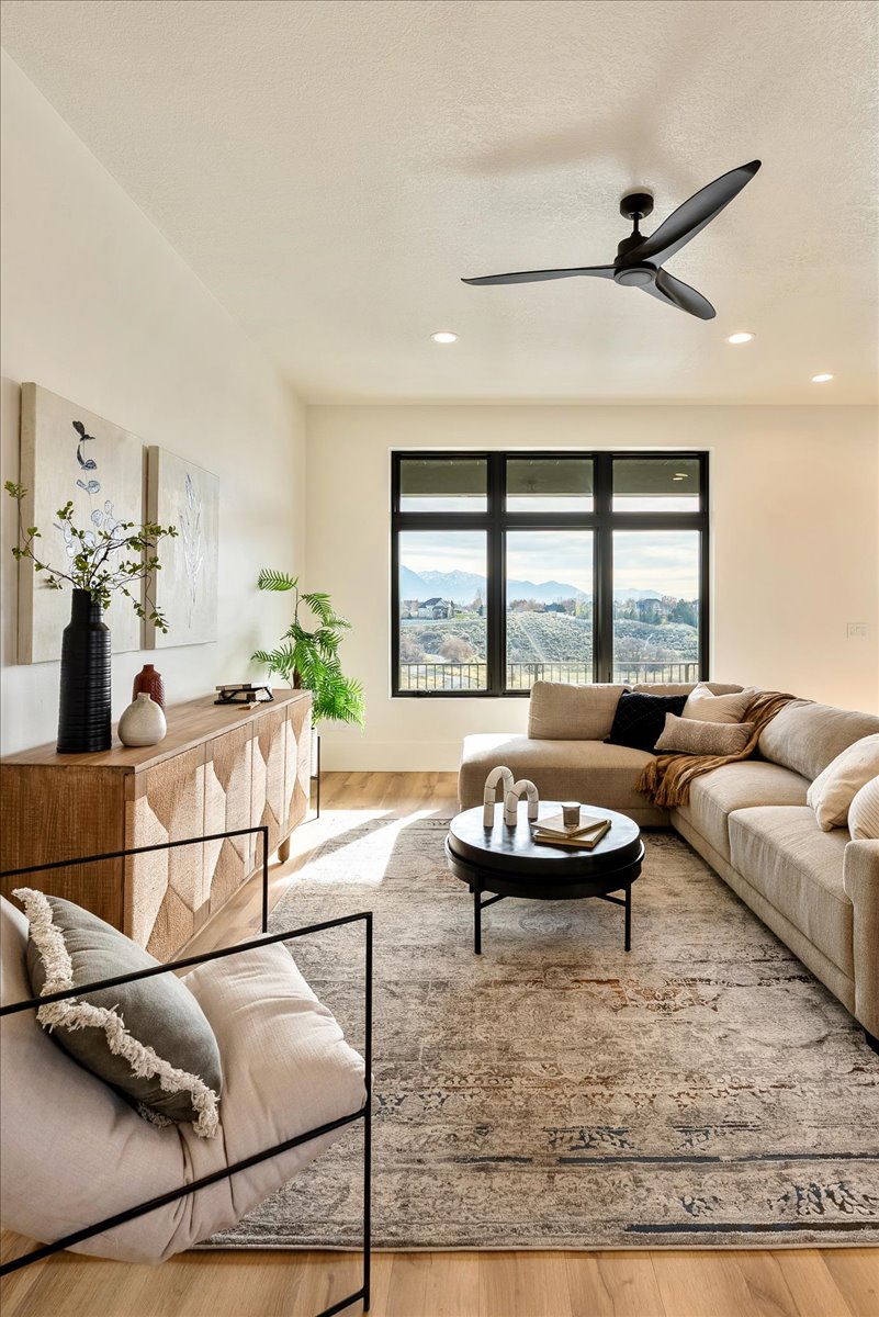 Living area with wood finished floors, a mountain view, and a ceiling fan