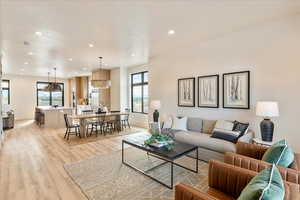 Living room with light wood-type flooring and recessed lighting