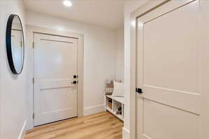 Entryway with wood finished floors and recessed lighting