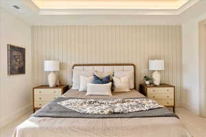 Bedroom featuring light carpet and baseboards