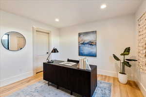 Office area featuring light wood finished floors and recessed lighting