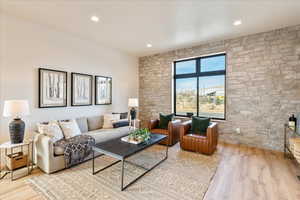 Living room with light wood finished floors and recessed lighting
