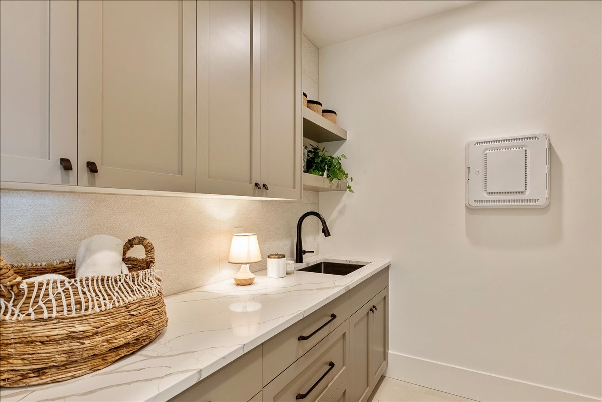 Bar featuring light stone countertops, open shelves, decorative backsplash, and gray cabinetry