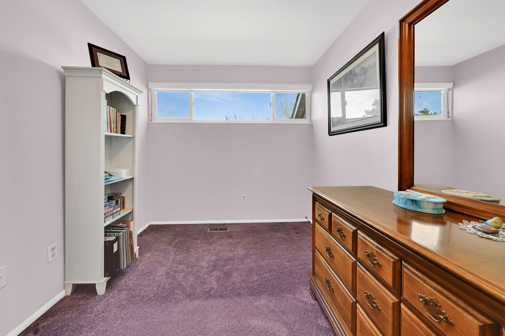Hallway featuring dark colored carpet and baseboards
