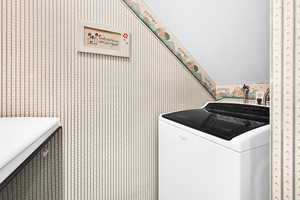 Laundry area featuring washer / clothes dryer and wallpapered walls