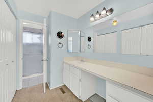Bathroom featuring vanity, light carpet, a closet, and a shower stall