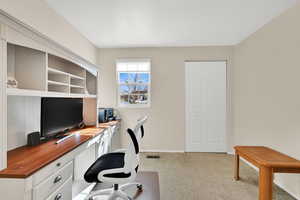 Office area featuring light colored carpet and baseboards
