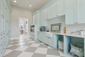 Laundry room with light flooring, two tone color scheme, washing machine and clothes dryer, light stone counters, and recessed lighting