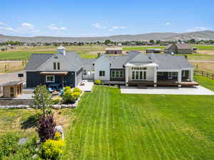 Rear view of property featuring roof with shingles, a patio area, french doors, and a mountain view