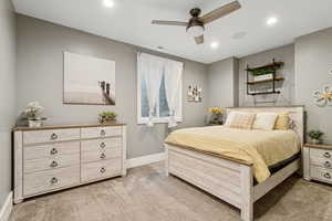 Bedroom featuring light colored carpet, ceiling fan, and recessed lighting