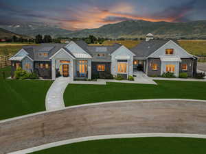 Modern farmhouse featuring a standing seam roof, a mountain view, and a yard