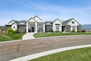 Modern inspired farmhouse with board and batten siding, a front yard, a mountain view, and a standing seam roof