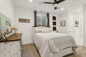 Bedroom featuring recessed lighting, light colored carpet, a ceiling fan, and ensuite bath