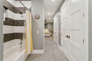 Full bathroom featuring ensuite bath, shower / tub combo, recessed lighting, light wood-style floors, and ceiling fan