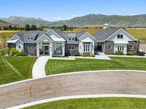 Modern farmhouse style home with a mountain view, a front yard, a standing seam roof, a chimney, and board and batten siding