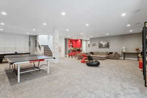 Recreation room with light colored carpet and recessed lighting