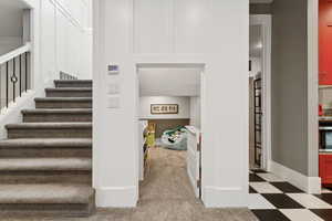 Staircase to basement with tile patterned floors and baseboards