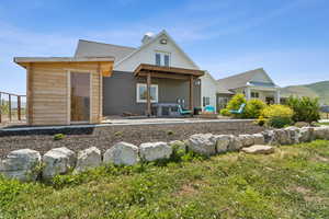 Rear view of house with a patio area, a mountain view, and a chimney