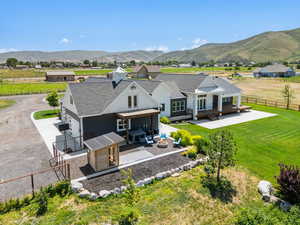 Back of house featuring a fenced backyard, a patio area, an outdoor fire pit, and a mountain view