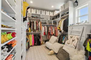 Primary Walk in closet with light carpet