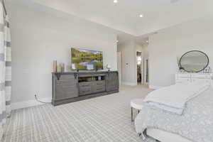 Primary Bedroom with light carpet and recessed lighting