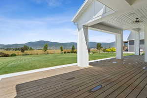 Wooden terrace featuring a mountain view and a view of rural / pastoral area