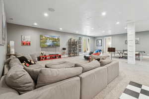 Carpeted living room with recessed lighting and baseboards