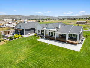 Back of property with board and batten siding, a shingled roof, a chimney, and a mountain view