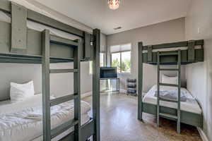 Bedroom with concrete flooring and baseboards