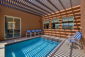 View of pool with patio surround, a pergola, and a swimming pool