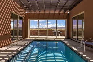 Indoor pool with a mountain view and a grill