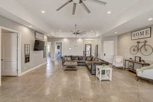 Living room featuring concrete flooring, a ceiling fan, and recessed lighting