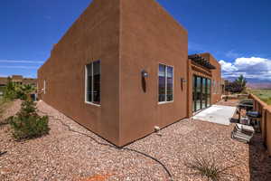View of side of home with stucco siding, a patio area, and a pergola